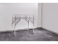 Foldable table with metal frame in an empty room with gray flooring.