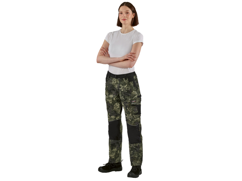 Woman in camouflage work trousers and white t-shirt with crossed arms.