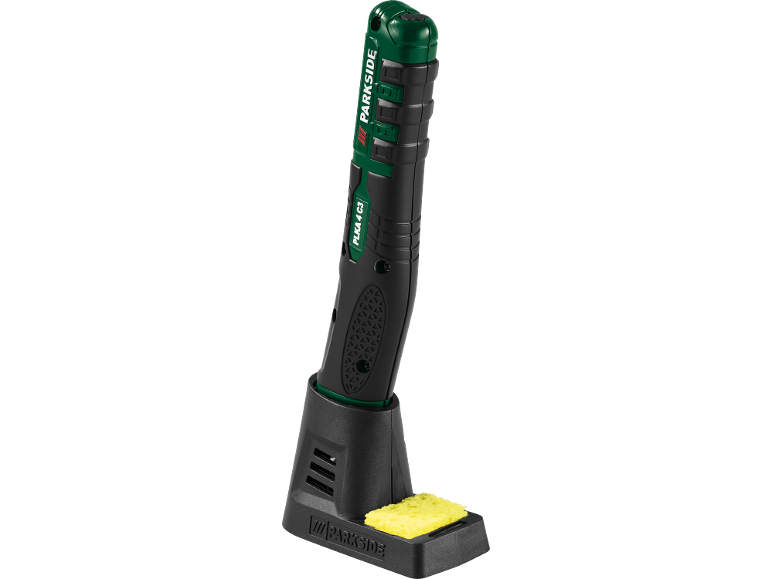 Black and green cordless soldering iron with charging base and sponge.