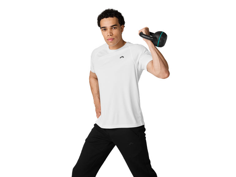 Man in white sports t-shirt and black joggers holding a kettlebell.