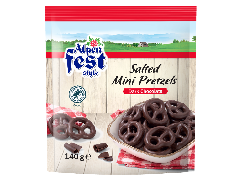 Dark chocolate salted mini pretzels in a bowl and scattered, with a scenic background.