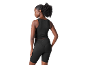 Woman in black sports crop top and cycling shorts, rear view.