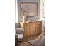 Wooden sideboard with decor, a vase with branches, and a framed abstract art print.