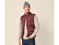 Smiling man wearing a burgundy puffer vest, beige sweater, and grey beanie.
