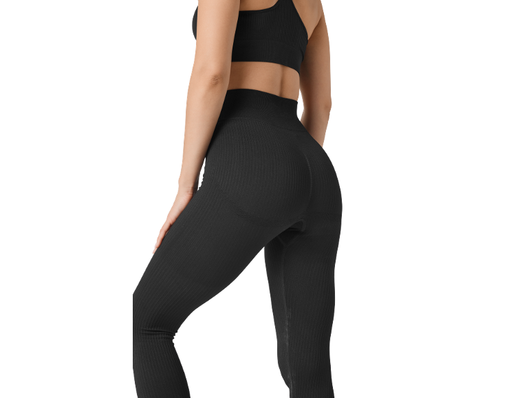 Woman in black ribbed leggings and sports top, rear view.
