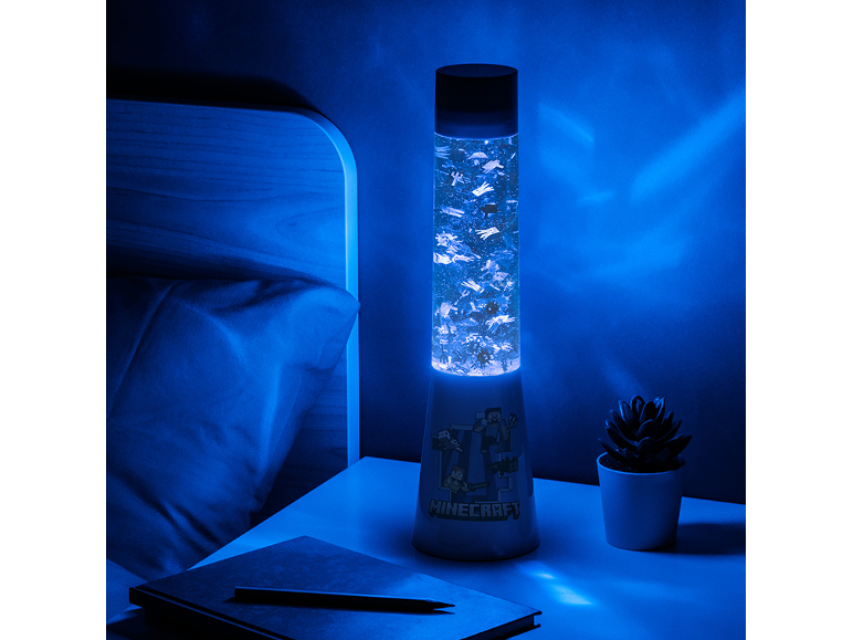 Blue tower lamp with thematic figures, on a nightstand next to a bed.