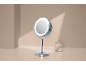 Lighted makeup mirror and cotton swabs on a beige background.