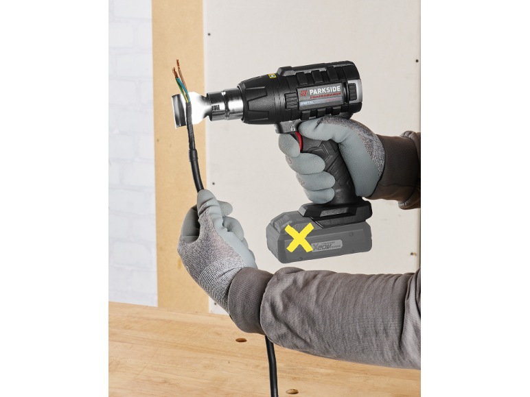Cordless heat gun with battery, used for insulating an electrical cable.