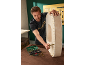 Man assembling a wooden item using a tool set.