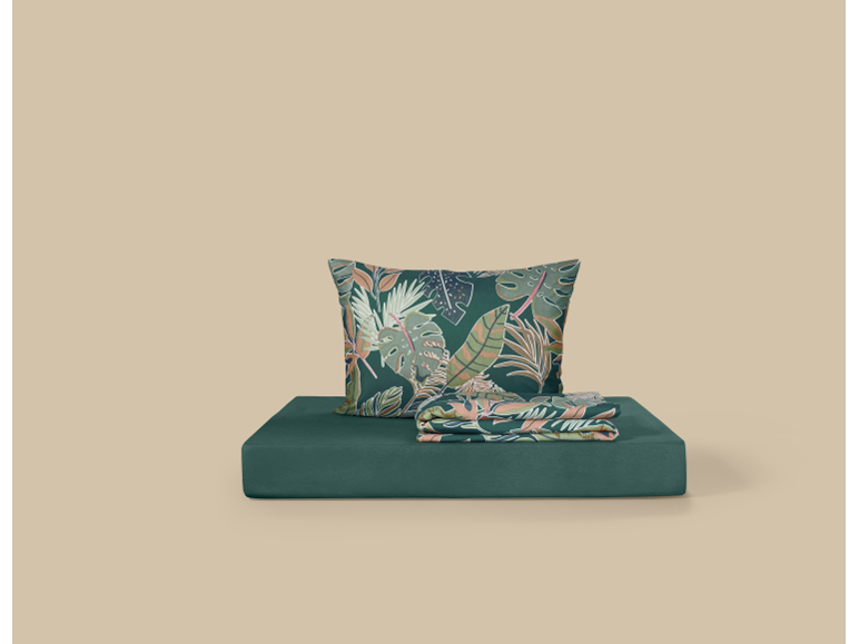 Pillow and blanket with tropical leaf print on a green base.