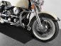Close-up of a classic motorcycle with a beige tank and chrome details.