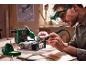 Man soldering electronics with a soldering station and magnifying glasses.