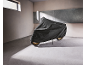 Motorcycle covered with a protective tarp in a garage with sunlight.