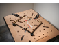 Gold and black picture frame on a perforated workbench with clamps.