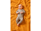 Baby in a grey ribbed knit outfit on an orange blanket.
