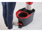 Person in jeans and white sneakers using a spin mop and bucket, water dripping from mop.