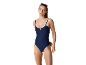 Woman in a dark blue ribbed one-piece swimsuit with pink sunglasses on her head.