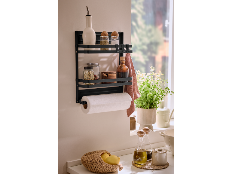Black kitchen shelf with spices, oil, paper towels, and herbs.