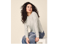Woman in light grey sweater and jeans, sitting and looking away.