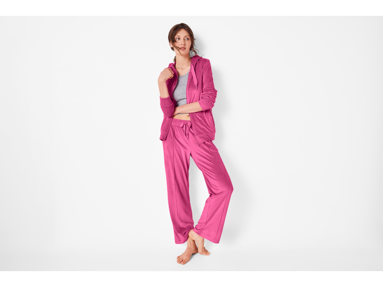 Woman in fuchsia pink tracksuit, zip-up jacket and wide-leg pants.