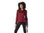 Woman in a maroon hooded jacket and black leggings holding trekking poles.