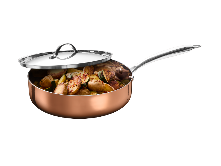 Copper pan with lid, filled with roasted potatoes and zucchini.