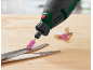 Rotary tool with pink grinding attachment ready to sharpen scissors.