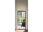 Black mosquito net on a door leading to a balcony with plants and furniture.