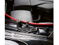 Red car battery cable secured on the engine.