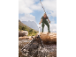Man in waders with a fishing rod and net in a river.
