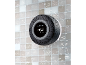 Waterproof bathroom speaker with time display, mounted on tiles with water droplets.