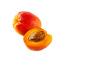 Two ripe apricots, one whole, the other cut in half with a visible pit.