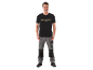 Man in black t-shirt with «PARKSIDE EST. 1996» inscription and grey work trousers.