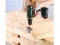 Cordless drill driving a screw into a wooden board with a hinge.