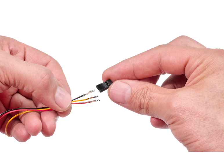 Hands connecting electrical wires to a black connector.