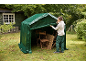 Woman closing a green garden tent with stored wooden garden furniture.