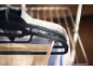 Clothes hangers with a white shirt and trousers on a drying rack.