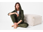 Woman in dark green velvet tracksuit and white t-shirt, sitting on the floor.