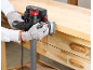 Person using an electric planer on a wooden workbench, with a dust extraction hose attached.