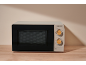 Beige microwave with control panel featuring wooden rotary knobs, on a wooden table.
