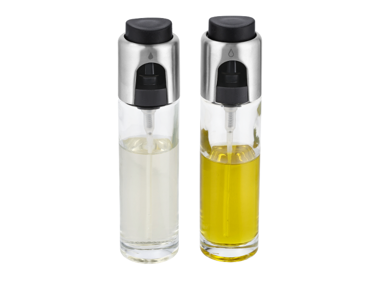Two glass oil spray bottles with silver and black caps, one with clear liquid and one yellow.