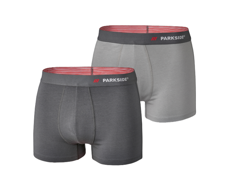 Two men's cotton boxer briefs, one dark grey and one light grey, with a red waistband.