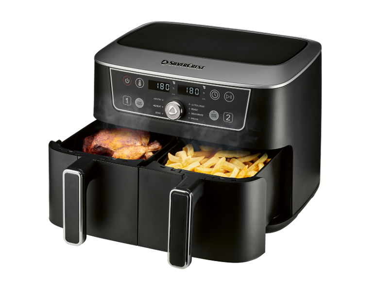 Black dual-basket air fryer cooking chicken and fries, with a digital display.