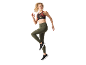 Woman in a patterned sports bra and green leggings with pockets.