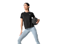 Woman in black t-shirt and blue leggings, holding a black medicine ball.
