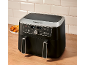 Black dual-drawer air fryer with digital display, chicken wings, and fries.