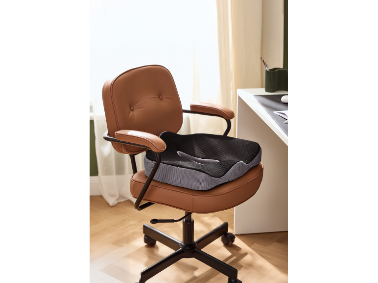 Brown office chair with a black and grey ergonomic cushion.