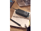Black power bank charging on an open notebook with a pen, a laptop in the background.
