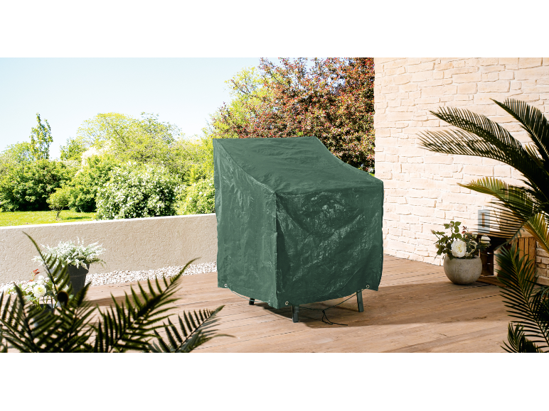Green protective cover for garden furniture on a wooden terrace.