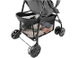 Close-up of a baby stroller's storage basket filled with a bottle, clothes, and a toy.